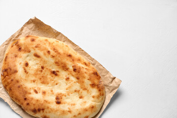 Baking paper with tasty lavash on white background