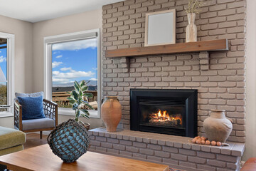 A cozy living room featuring a warm fireplace and an expansive large window