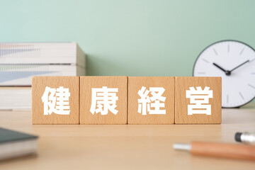 健康経営と書かれたブロックが置かれたデスク