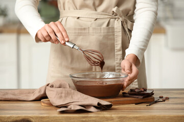 Woman preparing hot chocolate on table in kitchen. Closeup