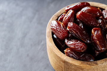 Dried Dates in Wooden Bowl on Dark Background, Top View, Copy Space