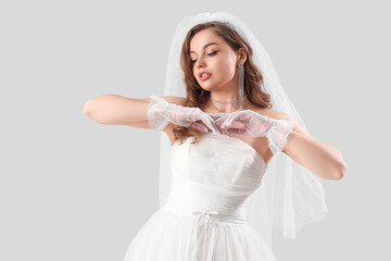 Beautiful bride in white wedding dress on light background