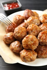 Many delicious meatballs on dark wooden table, closeup