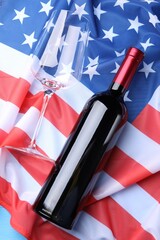 Wine and American flag on blue table, flat lay