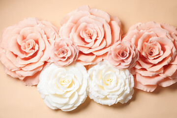 Beautiful paper flowers on beige background, flat lay