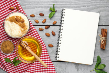 Blank recipe book, dessert and ingredients on grey wooden table, flat lay