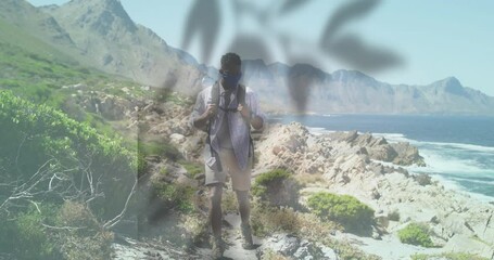 Hiking along rocky coastal path, man with animation of abstract shapes overlaying - Powered by Adobe