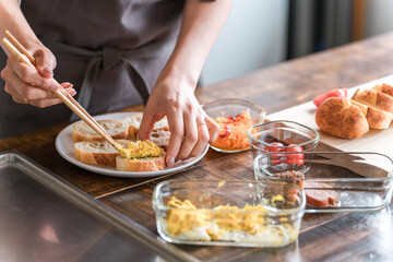 キッチンでブルスケッタを作る女性の手元
