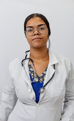 Medical concept of beautiful Brazilian female doctor in white coat with stethoscope, waist up....
