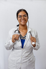 Medical concept of beautiful Brazilian female doctor in white coat with stethoscope, waist up....