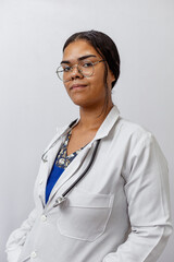 Medical concept of beautiful Brazilian female doctor in white coat with stethoscope, waist up....