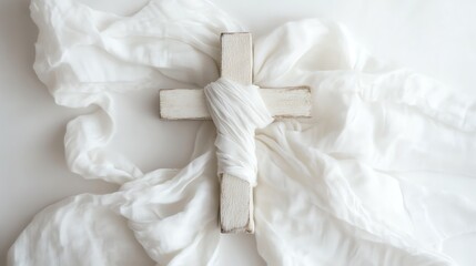 Obraz premium Neutral Wooden Cross Wrapped in White Fabric Against a Soft, Textured Background