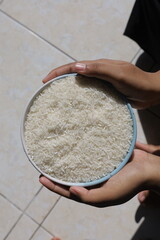 both hands hold the rice in the bowl