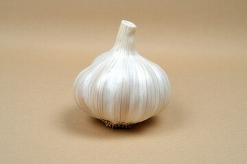 An Isolated Garlic Bulb Posed On A Smooth Beige Surface