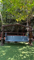 swimming pool in tropical resort,Patio white wooden hanging swing in outdoor green garden in backyard porch of home hanging furniture nobody in Florida tropical house