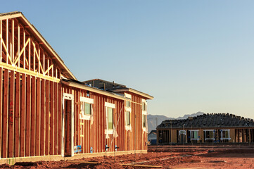 Wood-framed houses under construction in a residential subdivision show early-phase homebuilding,...