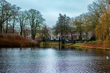 Fototapeta premium A pond with a bridge over it and a few houses in the background