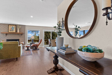A stylish living room featuring a table and a decorative mirror