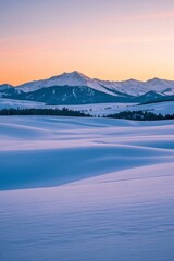 Obraz premium snowy landscape with mountains in the distance at sunset