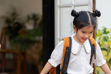 School Readiness and Excitement. A young girl enthusiastically prepares for school with her...