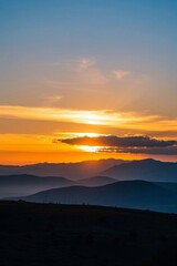 Obraz premium araffes in the distance with mountains in the background at sunset