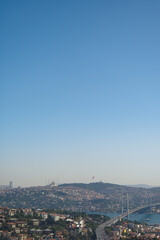 View of a bustling city landscape with a bridge under clear skies