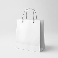 white paper bag shopping bag mockup stands against a black background. The bag has a wide base, with two thin handles rising to the top.