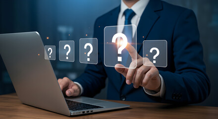 Businessman Interacting with Virtual Question Marks via Laptop on Wooden Desk in Blue Suit and Tie During Consulting Session