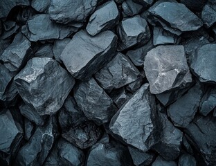 Dark grey stones tightly packed together.  Close-up view of rough, textured surfaces