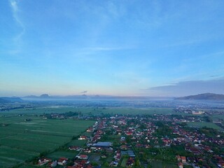Aerial photography of rural settlement rice field scenery, sunrise in the morning with beautiful dew mist