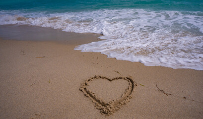 Sea beach sand. Scenic sea beach backdrop. Paradise ocean view. Heart drawn in sand. Waves forming a heart shape sign. Love on beach. Romantic summer. Heart made of sand. Love and ocean waves.