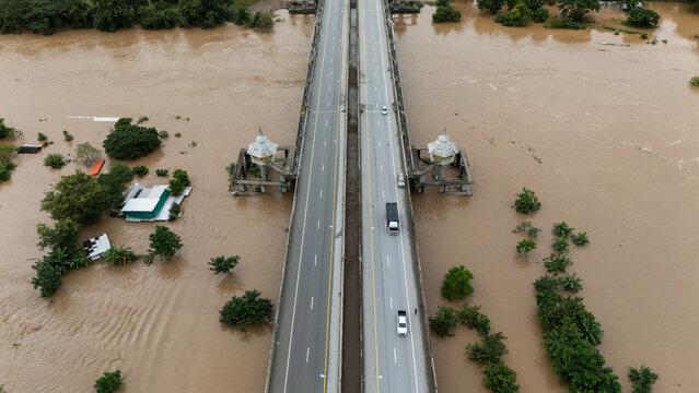 Aerial view of car driving on the bridge while water rising during typhoon Yagi has swept Chiang Rai province of Thailand.