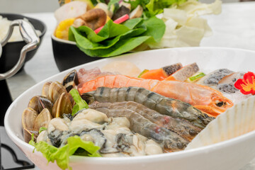 This seafood hot pot showcases an abundant variety of ocean-fresh ingredients, beautifully arranged and ready to be simmered in a bubbling pot of flavorful broth. From succulent shrimp, tender squid