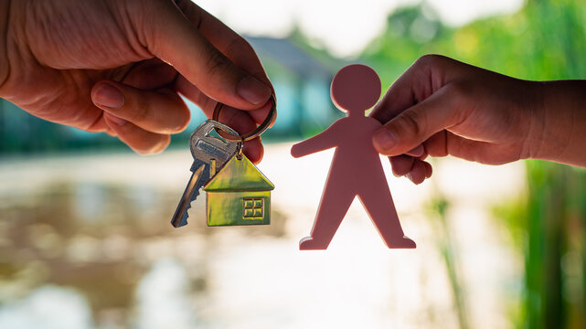 Father holding a model house and key to pass on to his son. The concept of handing over a business to an heir, making a will to order an inheritance to children.