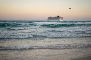 Cruise ship on the ocean. Luxury liner at ocean waves water. Miami Beach with cruise ship. Turquoise water and cruise liner. Tourist cruise ship near the coast. Ocean waves and vessel boat.