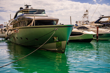 Fototapeta premium Yacht sailing on sea waters. Luxury superyacht at sea. Miami Beach with yachts. Seascape with a sailboat. Cruise ship near the coastline. Sunset yacht voyage in Florida. Luxury sailboat yacht.