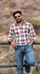 young man in shirt and jeans in a park