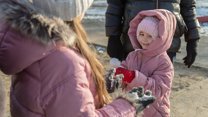 Grandparents with granddaughters playing in the park on a sunny winter day