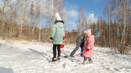 Playful family enjoying snowball fight in snowy winter park