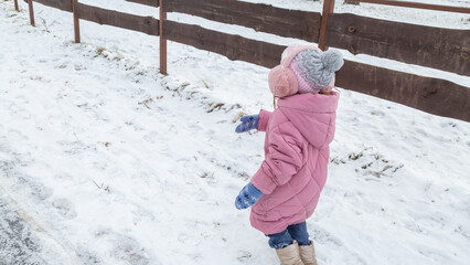 Little girls walking in park on snowy winter day