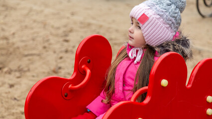 Little girl having fun on playground. Happy healthy little child climbing, swinging and sliding on...