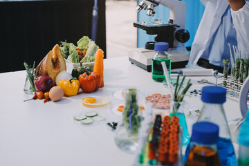 Team Asian scientists in a lab conducting food research using a microscope and lab equipment,...