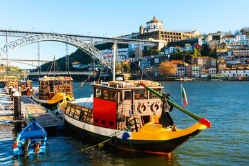 Porto, Portugal. Bridge Ponte Luis I over Douro river. Old traditional boats on the river.