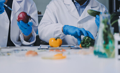 Team Asian scientists in a lab conducting food research using a microscope and lab equipment,...