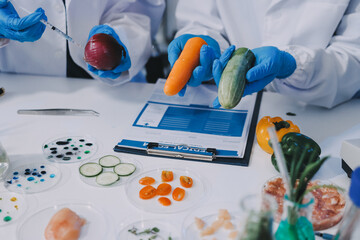 Team Asian scientists in a lab conducting food research using a microscope and lab equipment,...