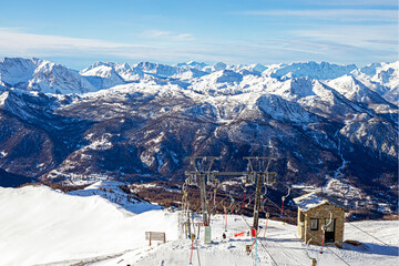 ski lift on top of a mountain in the Alps illuminated by the early sun