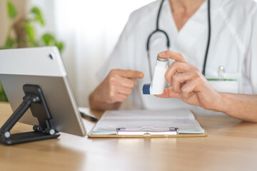 Allergist doctor pointing at an asthma inhaler during a consultation, discussing treatment options and explaining proper corticosteroid usage for respiratory disease management