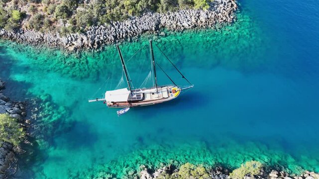 Aerial view of Gulet ship navigating the coastline under a blue sky