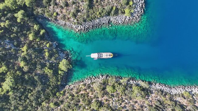 Aerial view of Gulet ship navigating the coastline under a blue sky