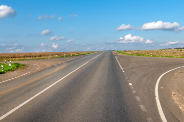 An intersection on an empty highway in an agricultural field